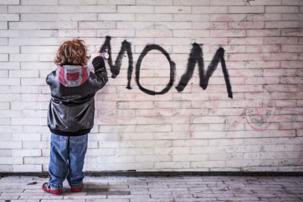 Kind schreibt mit Graffiti "Mama" auf Wand und drückt damit Schrei nach Liebe aus